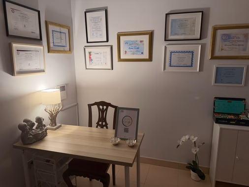 Recibidor con escritorio y diplomas en la pared