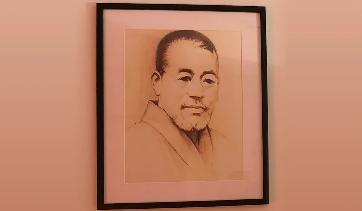 Retrato a lápiz de Mikao Usui en kimono, enmarcado en negro y colgado en una pared de luz cálida de nuestro centro de Bilbao