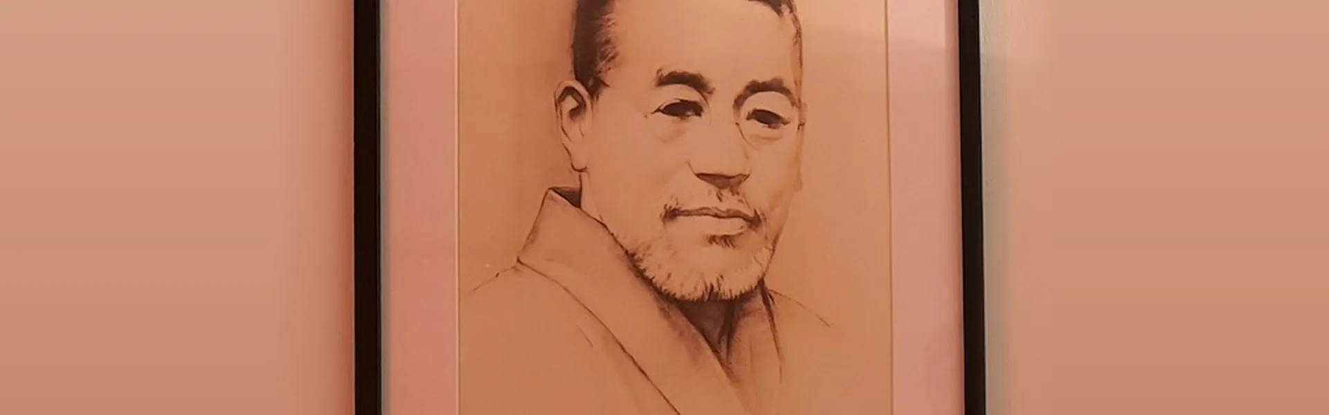 Retrato a lápiz de Mikao Usui en kimono, enmarcado en negro y colgado en una pared de luz cálida de nuestro centro de Bilbao